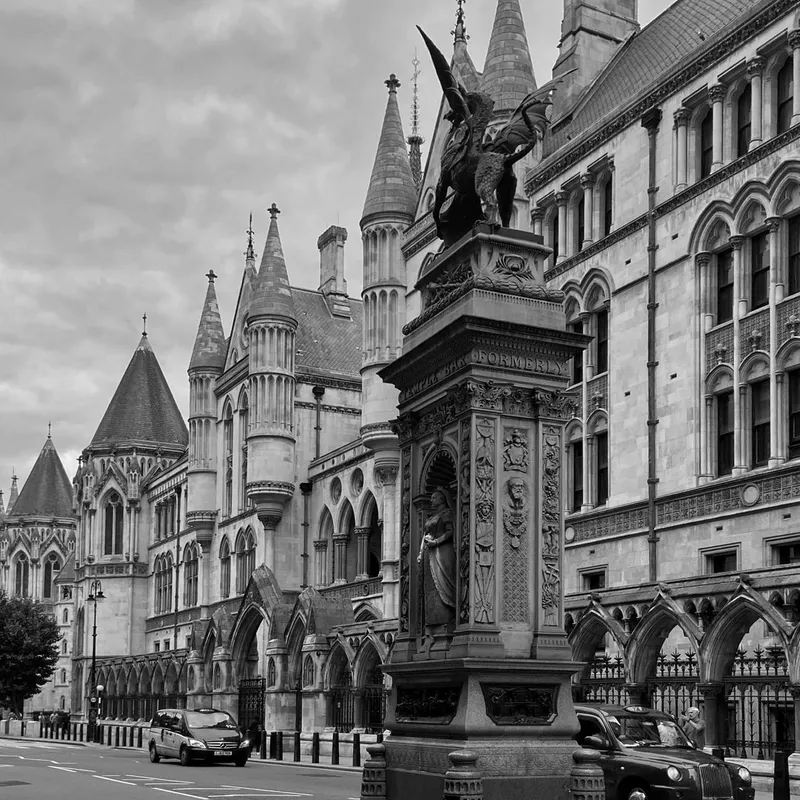 The Strand in London, with black cabs passing the Temple Bar memorial and the Royal Courts of Justice
