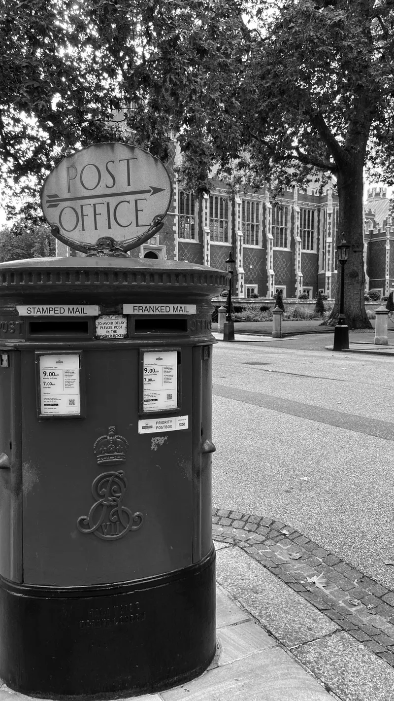 A red Post Office pillar box on a London street